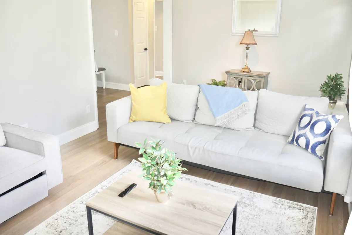 A spacious living area with a comfortable sofa and coffee table, enhanced by tasteful decorative elements. The atmosphere is welcoming and designed for relaxation or informal gatherings.